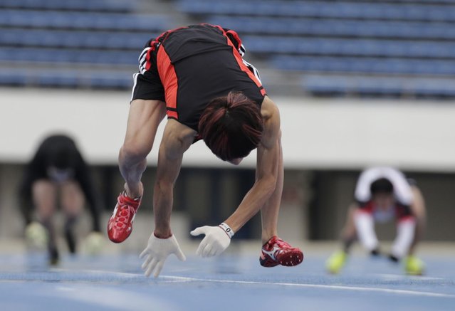 Kenichi Ito runs on his arms and legs on a race course on his way to setting the Guinness World Record fastest time for the 100-meter dash on all fours at Komazawa Olympic Park Stadium in Tokyo Thursday, November 14, 2013. The 30-year-old Japanese finished in 16.87 seconds Thursday, shaving more than half a second off his 2012 run of 17.47. (Photo by Shizuo Kambayashi/AP Photo)
