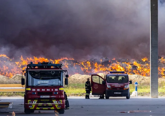 A firefighter stands near the fire at Drava International factory near Osijek, Croatia on October 4, 2023. (Photo by Antonio Bronic/Reuters)