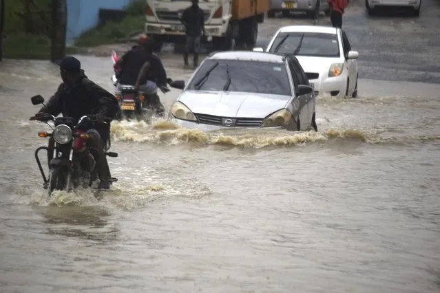 Motorists wade through a flooded road in Mombasa town after a heavy downpour on Friday November 3, 2023. Most of the roads remained impassable due to poor drainage system within the town. (Photo by Gideon Maundu/AP Photo).