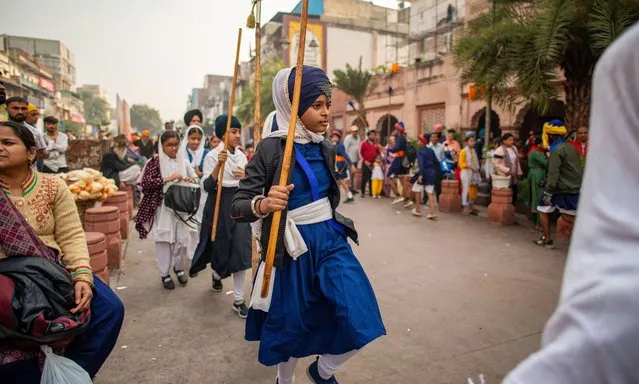 Sikh girls are enthusiastically demonstrating their skills in various activities during the long and colorful Nagar Kirtan procession near Shish Ganj Gurudwara on the day before the Prakash Parv (554th birth anniversary of Sri Guru Nanak Dev Ji) in Old Delhi on November 26, 2023. The celebration of Guru Nanak Dev Ji's birthday is marked with various activities and events within the Sikh community. Gurdwaras (Sikh temples) are decorated, and special prayers, kirtan (devotional singing), and processions are organized by Sikh. (Photo by Pradeep Gaur/SOPA Images/Rex Features/Shutterstock)