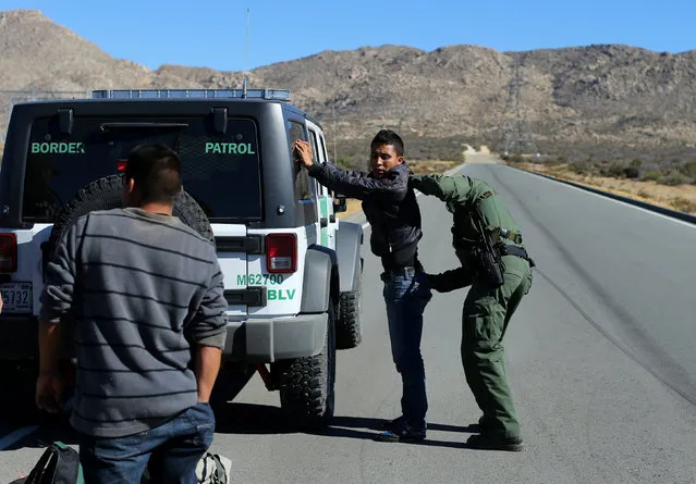 U.S. Border Patrol supervisor Bobby Stine frisks a man a few hundred meters from the U.S.-Mexico border fence near Jacumba, California, U.S., November 14, 2016. (Photo by Mike Blake/Reuters)
