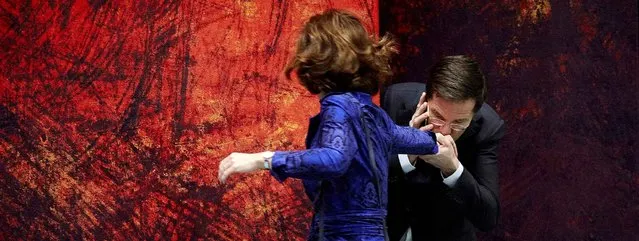 Netherlands' Prime Minister Mark Rutte (R) gives a kiss on the hand of chamber chairman Anouchka van Miltenburg before the start of the debate about the calendar for the European Summit on December 18, 2013. (Photo by Martijn Beekman/AFP Photo/ANP)