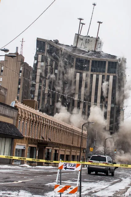 The Genesee Towers fall to the ground as explosives detonate for an implosion, Sunday, December 22, 2013 in downtown Flint, Mich. (Photo by Jake May/AP Photo/The Flint Journal)