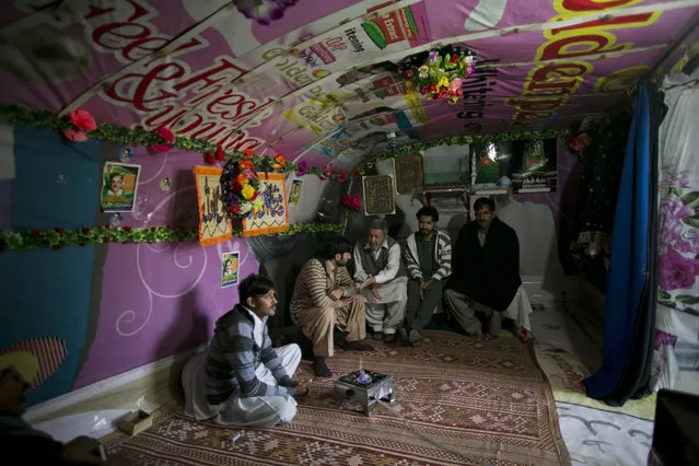 People sit in a cave where they reside in Hasan Abdal, Thursday, February 4, 2016. Hundreds of of families live in caves as their homes equipped with all modern amenities, such as running water, electricity and cable television, built by their forefathers in surroundings of Hasan Abdal, 45 kilometers from capital. (Photo by B.K. Bangash/AP Photo)