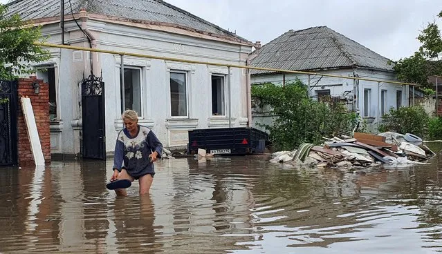 A woman walks along a flooded street following heavy rainfall in Kerch, Crimea August 16, 2021. (Photo by Alla Dmitrieva/Reuters)