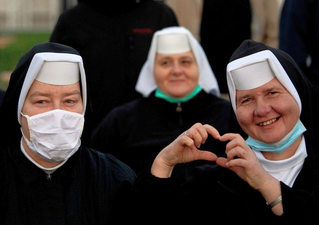 A nun forms a heart with her hands waiting with fellow worshippers at the site of the open air Holy Mass to be celebrated by Pope Francis at The National Shrine in Sastin-Straze, some 70 km norht of the Slovakian capital Bratislava on September 15, 2021. (Photo by Joe Klamar/AFP Photo)
