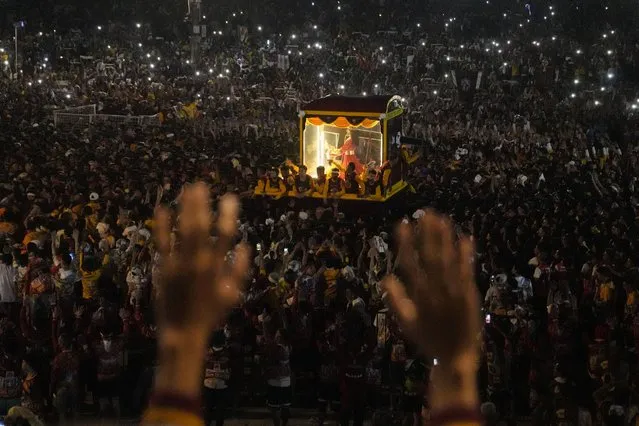 Devotees raise their hands during the annual Black Nazarene procession which was resumed after a three-year suspension due to the coronavirus pandemic on Tuesday, January 9, 2024 in Manila, Philippines. A mammoth crowd of mostly barefoot Catholic devotees joined a chaotic procession through downtown Manila Tuesday to venerate a centuries-old black statue of Jesus Christ with many praying for peace in the Middle East where Filipino relatives work. (Photo by Aaron Favila/AP Photo)