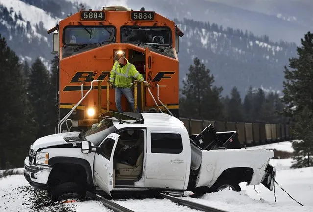 A Montana Rail Link official looks over the scene after a Burlington Northern Sante Fe train collided with a pickup truck at a crossing west of Alberton, Mont., Tuesday, February 19, 2019, injuring the driver of the truck. The truck was pushed about a half a mile down the track before the train could stop. The track is owned by Montana Rail Link. (Photo by Kurt Wilson/The Missoulian via AP Photo)
