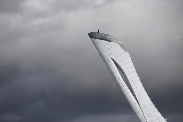 A worker is dwarfed against the sky as he stands at the top of the Olympic cauldron ahead of the 2014 Winter Olympics, Tuesday, February 4, 2014, in Sochi, Russia. (Photo by Wong Maye-E/AP Photo)