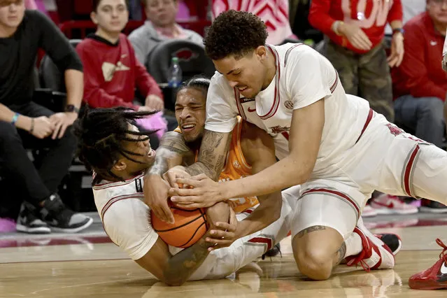 Arkansas players Khalif Battle, left, and Jalen Graham, right, and Tennessee guard Zakai Zeigler scramble for control of the ball during the first half of an NCAA college basketball game Wednesday, February 14, 2024, in Fayetteville, Ark. (Photo by Michael Woods/AP Photo)