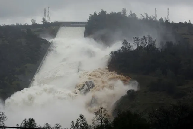 Water flows through break in the wall of the Oroville Dam spillway, Thursday, February 9, 2017, in Oroville, Calif. The torrent chewed up trees and soil alongside the concrete spillway before rejoining the main channel below. Engineers don't know what caused what state Department of Water Resources spokesman Eric See called a “massive” cave-in that is expected to keep growing until it reaches bedrock. (Photo by Rich Pedroncelli/AP Photo)