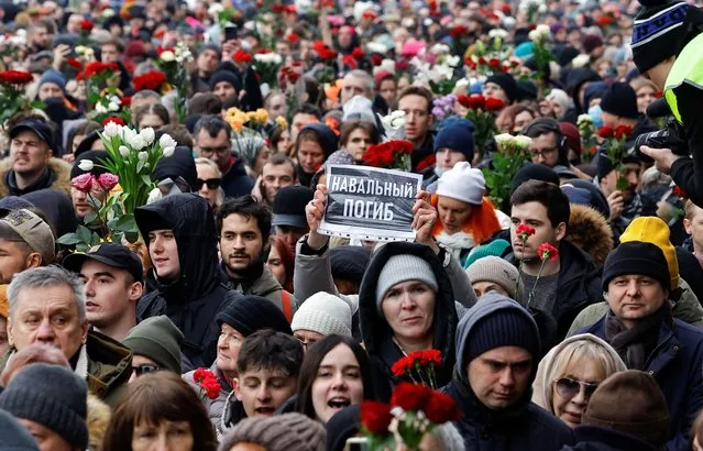 People walk towards the Borisovskoye cemetery during the funeral of Russian opposition politician Alexei Navalny in Moscow, Russia, on March 1, 2024. A placard reads: “Navalny died”. (Photo by Reuters/Stringer)