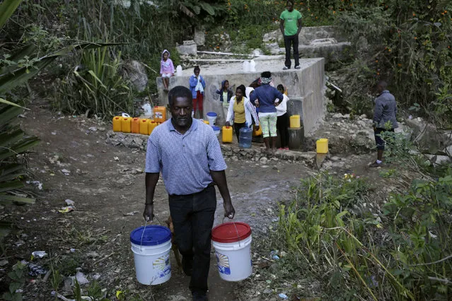 Andre Louis Jean carries two buckets of water at a fountain in the outskirts of Kenscoff, Haiti, February 23, 2016. March 22 marks World Water Day. (Photo by Andres Martinez Casares/Reuters)