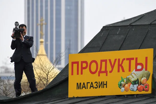 A North Korean cameraman takes up a position on the roof of a building near the train station where North Korean leader Kim Jong Un is expected to arrive, in the far-eastern Russian port of Vladivostok on April 24, 2019. (Photo by Kirill Kudryavtsev/AFP Photo)