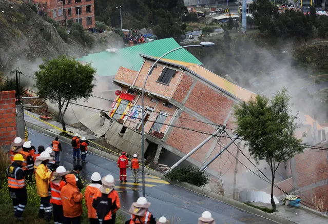 Members of a rescue team watch collapsed buildings due to landslide following heavy rains in la Periferica district in La Paz, Bolivia on April 30, 2019. (Photo by David Mercado/Reuters)