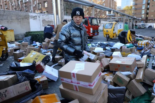 Delivery workers sort parcels at a makeshift logistics station near the Central Business District (CBD) during Singles’ Day shopping festival in Beijing, China on November 11, 2021. (Photo by Tingshu Wang/Reuters)
