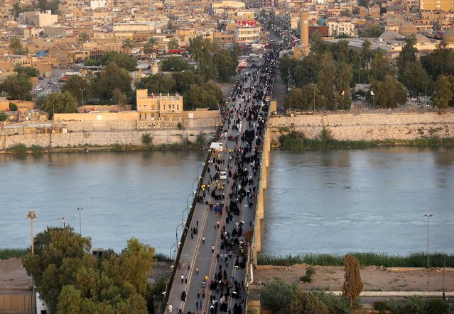 An aerial view shows Shiite pilgrims walk towards the festival of Imam Moussa al-Kazim as pilgrims gather to commemorate his death, in the Shiite district of Kazimiyah, Baghdad, Iraq, Wednesday, May 13, 2015. (Photo by Hadi Mizban/AP Photo)