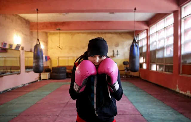 In this Wednesday, March, 5, 2014 photo, an Afghan female boxer pauses during a practice session at the Kabul Stadium boxing club. The Afghanistan National Olympic Committee boxing club has fewer than a dozen women and little money for them. Previously nongovernmental organizations supported them. At that time there were 25 young women who received a salary the equivalent of $100 per month and transportation to and from the Kabul Stadium where they train. (Photo by Massoud Hossaini/AP Photo)
