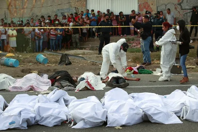 Bodies in bodybags are placed on the side of the road after an accident in Tuxtla Gutierrez, Chiapas state, Mexico, December 9, 2021. (Photo by AP Photo/Stringer)