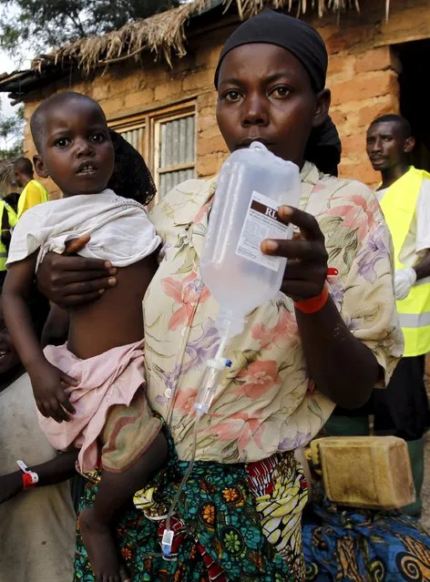 A Burundian refugee carries her sick child as she receives treatment at a makeshift clinic on the shores of Lake Tanganyika in Kagunga village in Kigoma region in western Tanzania, as they wait for MV Liemba to transport them to Kigoma township, May 17, 2015. (Photo by Thomas Mukoya/Reuters)