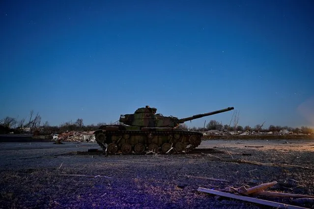 A tank sits in a heavily damaged neighborhood at dawn after tornadoes ripped through several U.S. states, outside a destroyed American Legion Post, in Dawson Springs, Kentucky, U.S., December 12, 2021. (Photo by Jon Cherry/Reuters)