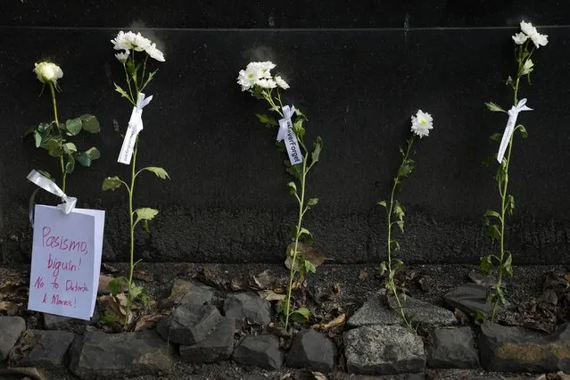 Flowers with slogans are left by activists at the “Bantayog ng mga Bayani” or Monument to the Heroes in Quezon City, Philippines as they condemn the fifth anniversary of the burial of the late dictator Ferdinand Marcos at the Heroes Cemetery on Thursday, Nov. 18, 2021. Filipino activists who were jailed, abused and tortured during late dictator Ferdinand Marcos' martial law asked the Commission on Elections Wednesday to disqualify his son and namesake from running for president next year, saying he may “whitewash” history and make it nearly impossible to recover plundered wealth. (Photo by Aaron Favila/AP Photo)