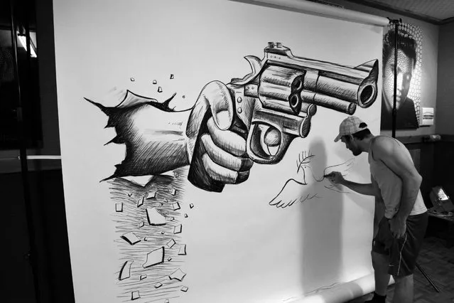 Visual artist Ben Heine at work in his studio while he creates one of his “anamorphic illusions” in Rochefort, Belgium