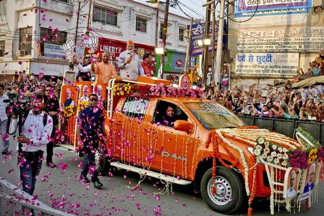 Indian Prime Minister Narendra Modi, center in a saffron cap, and Chief Minister of Uttar Pradesh Yogi Adityanath, in saffron robes, ride in an open vehicle as they campaign for Bharatiya Janata Party (BJP) for the upcoming parliamentary elections in Ghaziabad, India, Saturday, April 6, 2024. (Photo by Manish Swarup/AP Photo)