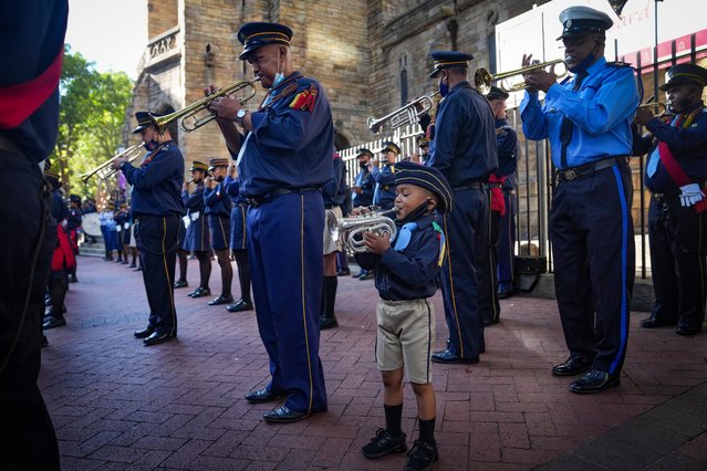 A young trumpeter joins the Anglican Church band as the coffin of late Archbishop Emeritus Desmond Tutu arrives outside the St. George's Cathedral in Cape Town, South Africa, 31 December 2021. The anti-apartheid leader and Nobel Peace Prize laureate, who was a key figure in the dismantling of apartheid, died on 26 December 2021 at the age of 90. A full state funeral will be held on 01 January 2022. (Photo by Nic Bothma/EPA/EFE)