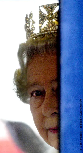 HRH Queen Elizabeth II peers around the side of her carriage as she leaves Parliament