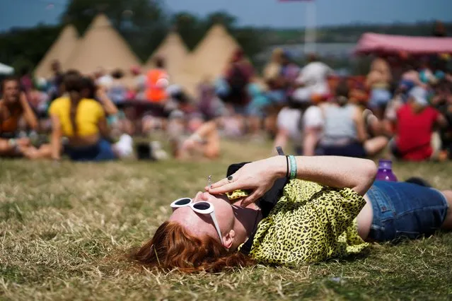 A festival goer relaxes in the sun during Glastonbury Festival at Worthy farm in Somerset, Britain on June 27, 2019. (Photo by Henry Nicholls/Reuters)