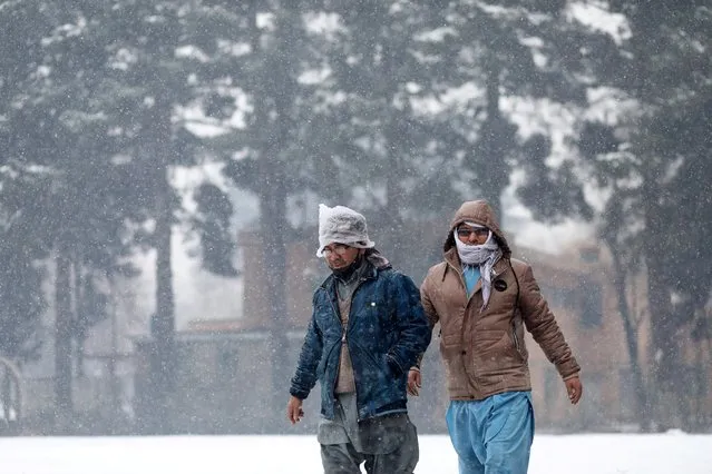 Afghan men walk during a snowfall in Kabul, Afghanistan, January 3, 2022. (Photo by Ali Khara/Reuters)