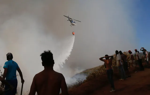 A helicopter makes a water drop to prevent a wildfire from spreading to homes in Vina del Mar, Chile, March 12, 2017. (Photo by Rodrigo Garrido/Reuters)