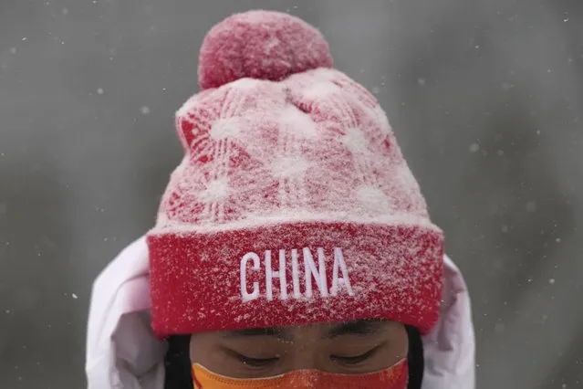 A member of the team China is covered by the snow as the start of the women's slopestyle qualification has been postponed due to a weather consition at the 2022 Winter Olympics, Sunday, February 13, 2022, in Zhangjiakou, China. (Photo by Francisco Seco/AP Photo)