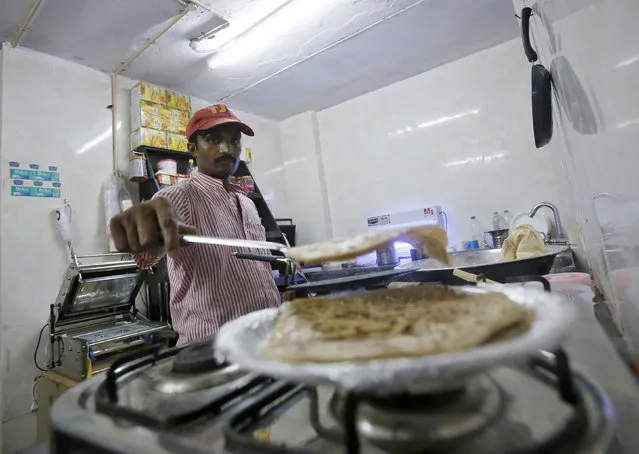 An inmate prepares food inside the kitchen of a restaurant run by the Tihar Jail authorities on Jail Road in west Delhi July 21, 2014. (Photo by Anindito Mukherjee/Reuters)