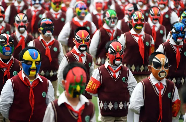 Students wearing Chinese opera masks do physical exercises on a playground in a primary school in Wuhan city, central China's Hubei province, 28 March 2017. More than 1,400 young students wearing Chinese opera masks did physical exercises on a playground in a primary school in Wuhan city, central China's Hubei province, on Tuesday (28 March 2017). The school encourages pupils to make opera masks by themselves to love traditional Chinese opera. (Photo by  Imaginechina/Rex Features/Shutterstock)