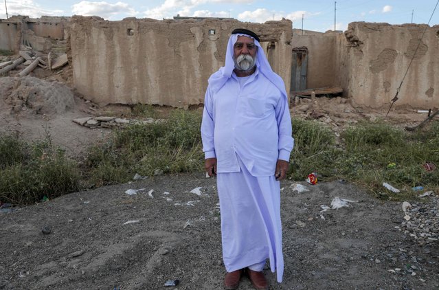 An Iraqi Yazidi man stands in front of a building destroyed during the 2014 attack by Islamic State (IS) fighters and the battles that followed, in the village of Solagh in the Sinjar region of the northern Iraqi Nineveh province on May 6, 2024. In August 2014, Islamic State (IS) fighters swept over Mount Sinjar, the Kurdish-speaking minority's historic home in northern Iraq, massacring thousands of Yazidis. (Photo by Safin Hamid/AFP Photo)