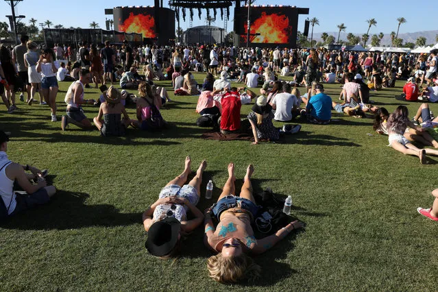 People lay down on the lawn in front of the main stage on the opening day of the Coachella Valley Music and Arts Festival on April 15, 2017 in Indio, California. (Photo by Carlo Allegri/Reuters)