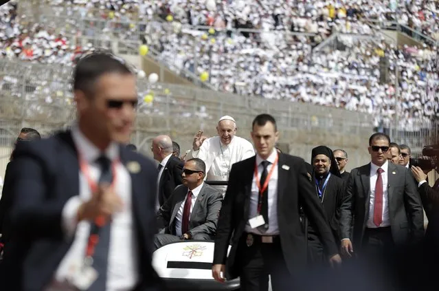 Pope Francis waves as he arrives to celebrate Mass for Egypt's tiny Catholic community, at the Air Defense Stadium in Cairo, Saturday, April 29, 2017. Pope Francis came to Egypt on Friday for a historic visit to the Arab and Muslim majority nation aimed at presenting a united Christian-Muslim front to repudiate violence committed in God's name. (Photo by Gregorio Borgia/AP Photo)