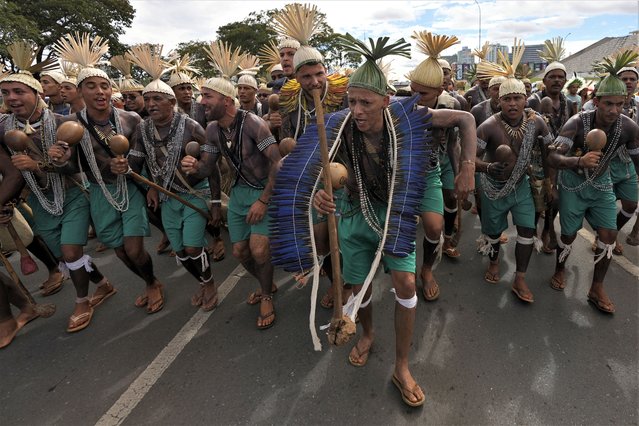 Indigenous people from various regions of Brazil take part in a demonstration in front of Congress to oppose bills that threaten their traditional lives, in Brasilia, Brazil, Monday, April 24, 2023. (Photo by Eraldo Peres/AP Photo)