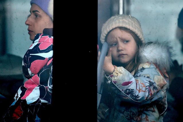 A child looks out from a bus window after fleeing from Ukraine to Romania, following Russia's invasion of Ukraine, at the border crossing in Siret, Romania, March 13, 2022. (Photo by Clodagh Kilcoyne/Reuters)