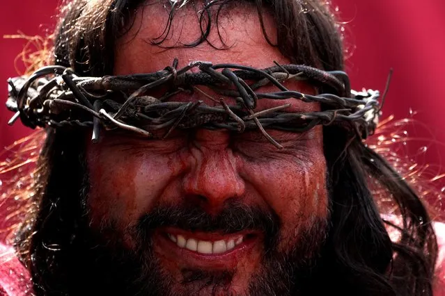 Portraying Jesus Christ, a parishioner reenacts the steps of Jesus Christ's final hours, in the traditional Good Friday procession, or the Stations of the Cross, in Pirenopolis, Brazil, Friday, April 15, 2022. Christians all over the world attend ceremonies that mark the day Jesus Christ was crucified, commonly known as Good Friday. (Photo by Eraldo Peres/AP Photo)