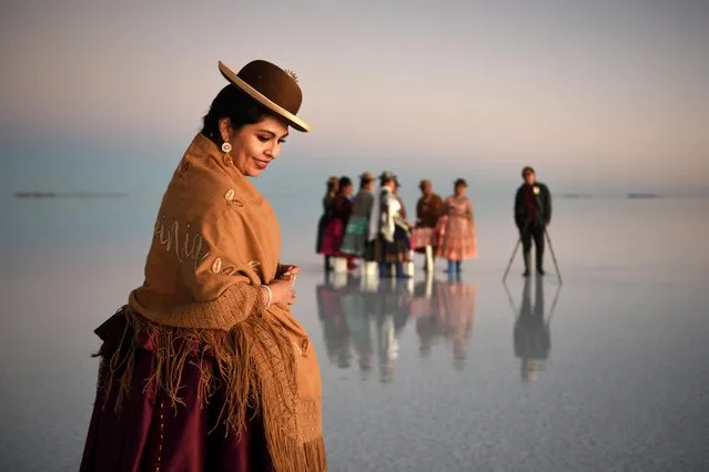Women in Cholita dresses pose for photos, at the Uyuni Salt Flat in Bolivia on March 26, 2022. (Photo by Claudia Morales/Reuters)