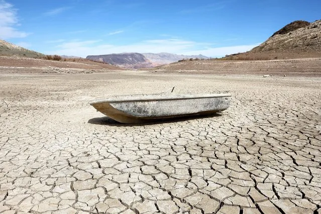 A formally sunken boat rests on a section of dry lakebed along drought-stricken Lake Mead on May 9, 2022 in the Lake Mead National Recreation Area, Nevada. The U.S. Bureau of Reclamation reported that Lake Mead, North America's largest artificial reservoir, has dropped to about 1,052 feet above sea level, the lowest it's been since being filled in 1937 after the construction of the Hoover Dam. Two sets of human remains have been discovered recently as the lake continues to recede. The declining water levels are a result of a climate change-fueled megadrought coupled with increased water demands in the Southwestern United States. (Photo by Mario Tama/Getty Images/AFP Photo)
