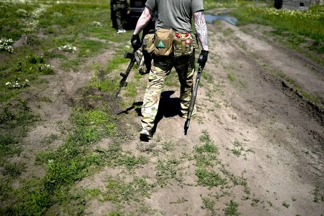 A civilian militia man holds a shotgun and a rifle during training at a shooting range in outskirts Kyiv, Ukraine, Tuesday, June 7, 2022. (Photo by Natacha Pisarenko/AP Photo)