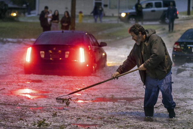 Rick Trapani clears out a storm drain after a car got stuck in floodwaters near 40th and Valley Streets in Omaha, Neb., Tuesday, June 7, 2022. Rain and hail from a storm pelted the area. (Photo by Chris Machian/Omaha World-Herald via AP Photo)