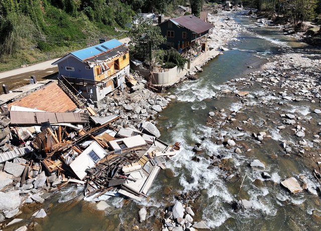 An aerial view of people standing near destroyed and damaged buildings in the aftermath of Hurricane Helene flooding on October 8, 2024 in Bat Cave, North Carolina. Bat Cave was particularly hard hit by flooding. Recovery efforts continue as the death toll has risen to over 230 while the powerful Hurricane Milton is on track to make landfall in Florida. (Photo by Mario Tama/Getty Images)