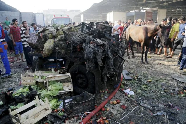 People gather at the site of a truck bomb attack at a crowded market in Baghdad August 13, 2015. (Photo by Wissm Al- Okili/Reuters)