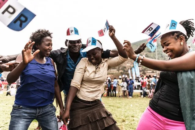 Supporters of the governing Rwanda Patriotic Front (RPF) dance during a campaign rally in Kigali, on July 30, 2017. The presidential elections will be held in Rwanda on 4 August 2017, pitting opposition presidential aspirants Frank Habineza of the the Democratic Green Party (DGP) and independent Philippe Mpayimana against incumbent President Paul Kagame who has been in charge of the country since 2000 after taking over from the then President Pasteur Bizimungu, who resigned paving the way for vice-president Kagame to take charge of the country ravaged by the 1994 genocide. (Photo by Marco Longari/AFP Photo)