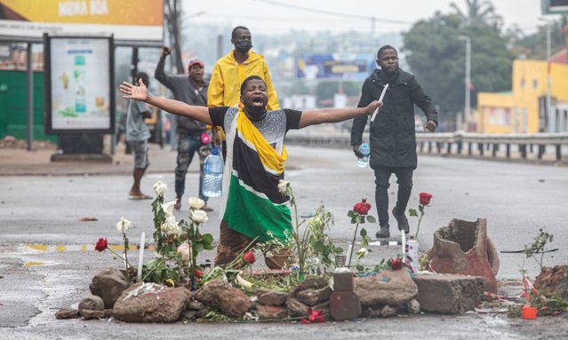 Supporters of the Optimist party for the development of Mozambique (PODEMOS) kneels over flowers placed in memory of two slain associates of the party during a strike called in Maputo, on October 21, 2024. A demonstration was dispersed with tear gas on Monday in the capital of Mozambique, which took on the air of a ghost town after a call for a general strike launched by the opponent Venancio Mondlane to denounce fraud during the presidential election, noted AFP. This demonstration comes two days after the assassination of two of the opponent's close associates, including his lawyer who was preparing an appeal to denounce fraud in the election of October 9. (Photo by Alfredo Zuniga/AFP Photo)